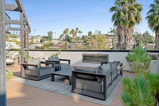 A patio with a couch, chairs and a table.