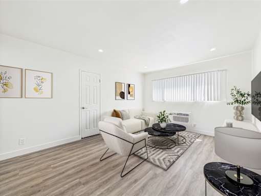 A living room with a white couch and a black coffee table.