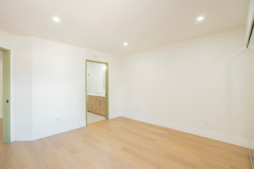a living room with white walls and a wooden floor