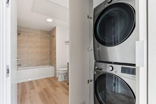 A modern laundry room with a washer and dryer built into the cabinetry.