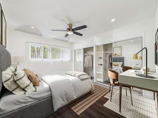 A bedroom with a bed, desk, and chair.