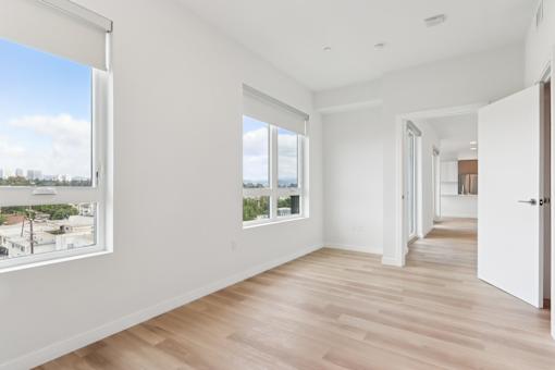 A spacious room with wooden floors and white walls.