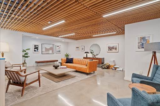 A living room with a wooden ceiling and furniture.