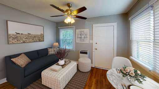 A living room with a couch, a table, and a painting on the wall.