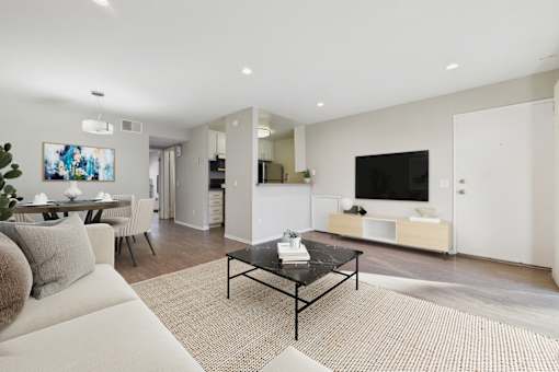 A modern living room with a black coffee table in the center.