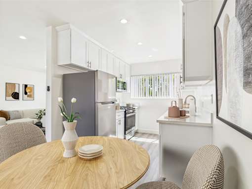A modern kitchen with a wooden table and chairs.