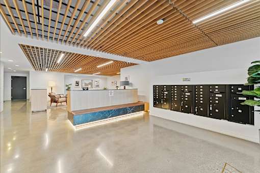 A reception area with a wooden ceiling and a white reception desk.