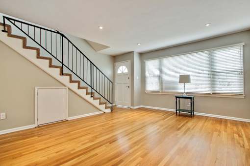 an empty living room with a staircase and a large window