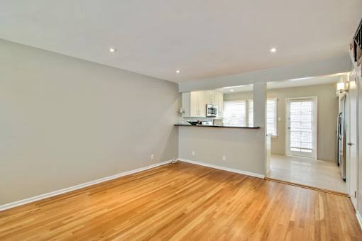 the living room and kitchen of an empty house with wood floors