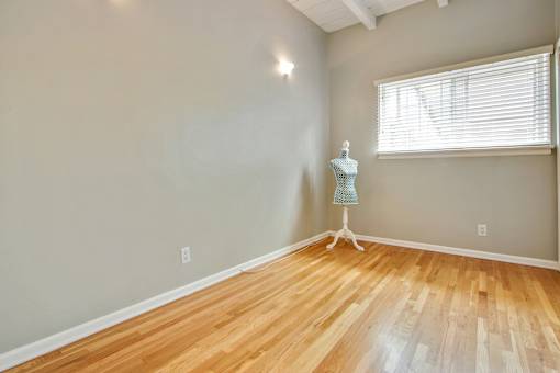 a room with a dresser and a window and wood floors