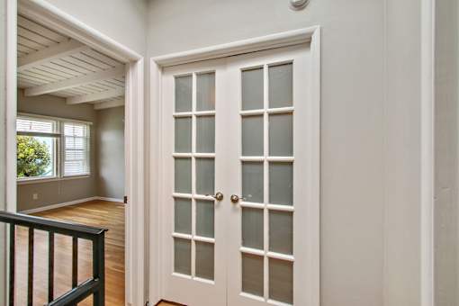 the entryway of a house with white doors and a staircase