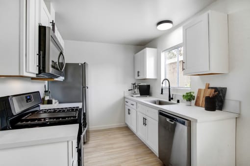a kitchen with white cabinets and stainless steel appliances