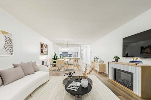 A modern living room with a white couch, a coffee table, and a fireplace.