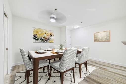 A dining room with a table set for four.
