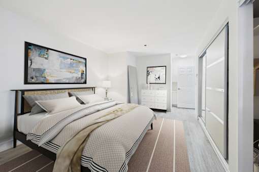 A bedroom with a large bed and a painting on the wall.