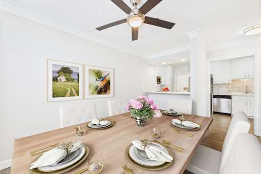 A dining room with a wooden table set for a meal.
