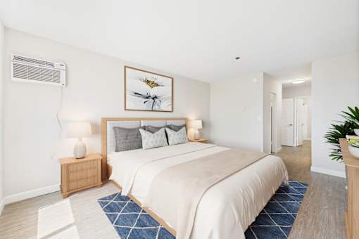 A bedroom with a large bed and a painting above it.