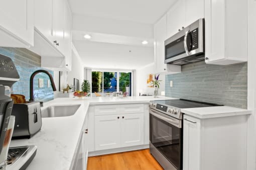 a white kitchen with a stove and a microwave
