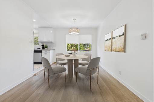 A dining room with a table and chairs.
