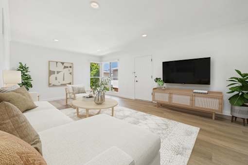 A living room with a white couch and a wooden coffee table.