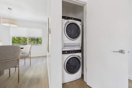 A modern laundry room with a washer and dryer built into the wall.