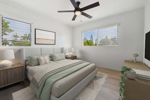 A bedroom with a large bed and a ceiling fan.