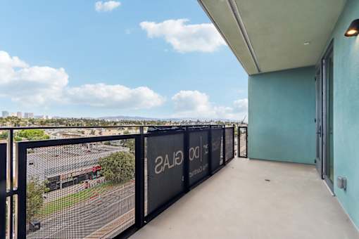 A balcony with a view of the city and a blue wall with the text "2A1300" on it.