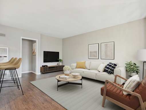 A living room with a white couch, a brown chair, and a grey rug.