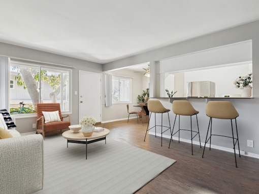 A living room with a white couch, a coffee table, and a window.