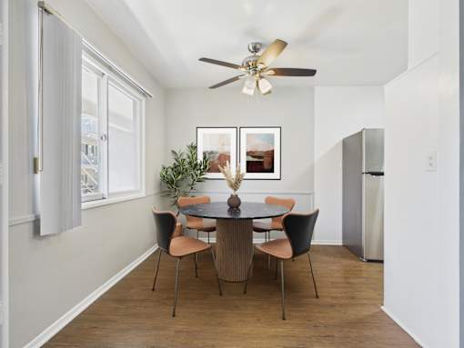 A dining room with a table and chairs.