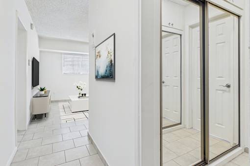 A hallway with a white door and a framed picture on the wall.