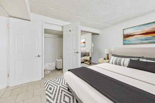 A bedroom with a large bed and a painting on the wall.