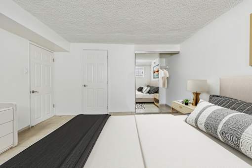 A bedroom with a bed, nightstand, and a yoga mat on the floor.