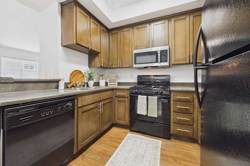 A kitchen with wooden cabinets and black appliances.