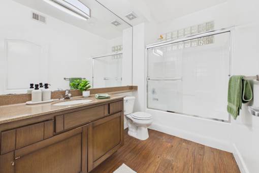 A bathroom with a wooden vanity and a white toilet.