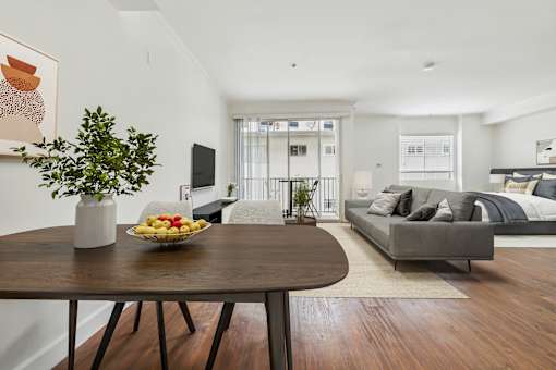 A dining table with a bowl of fruit and a vase of flowers on it.