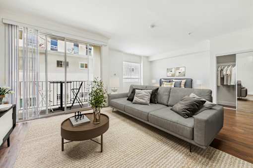 A living room with a grey couch and a brown coffee table.