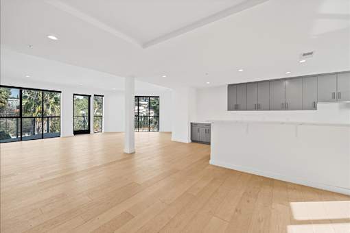 A spacious room with wooden floors and white walls.