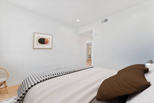 A bed with a brown pillow and a striped blanket.