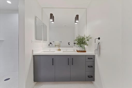 A bathroom with a grey cabinet and a white sink.