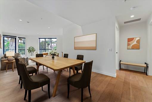 A dining room with a wooden table and chairs.