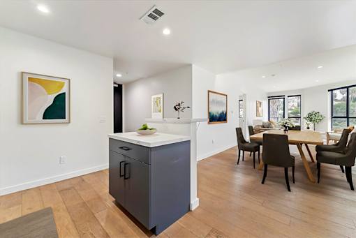 A kitchen with a dining table and chairs.