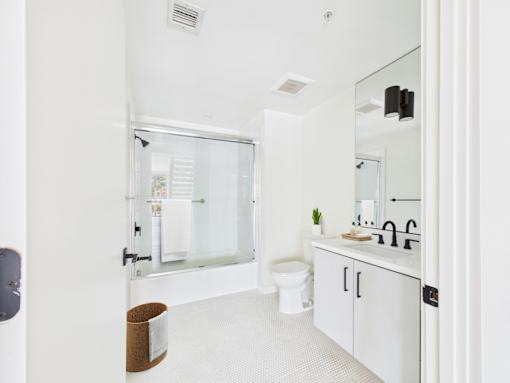 A white bathroom with a toilet, sink, and mirror.