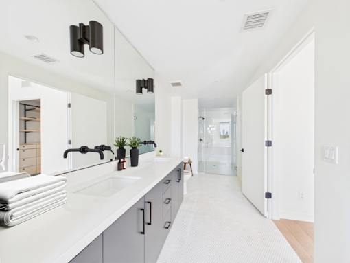 A bathroom with a white counter top and a white sink.