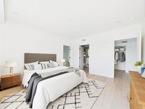 A large bedroom with a large bed and a wooden bench.