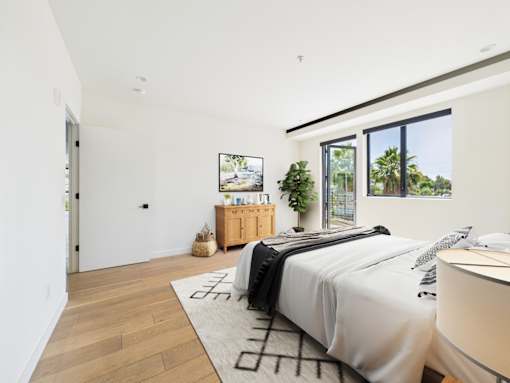 A bedroom with a large bed and a wooden cabinet.