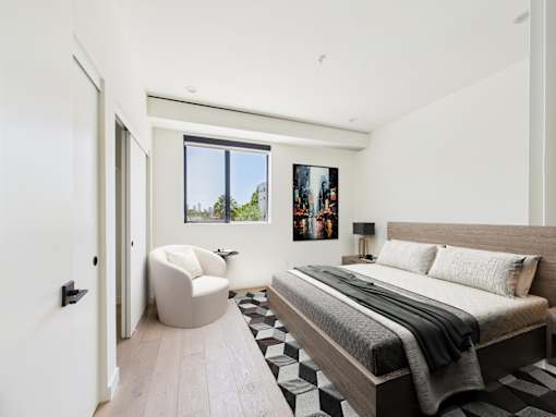 A modern bedroom with a large bed and a chair.