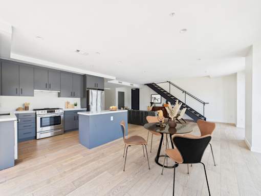 A modern kitchen with a dining table and chairs.