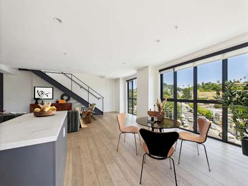 A modern kitchen with a dining table and chairs.