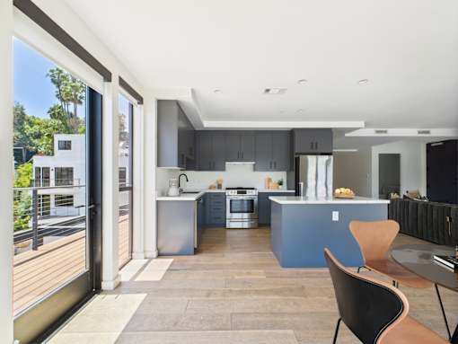 A modern kitchen with a dining table and chairs.